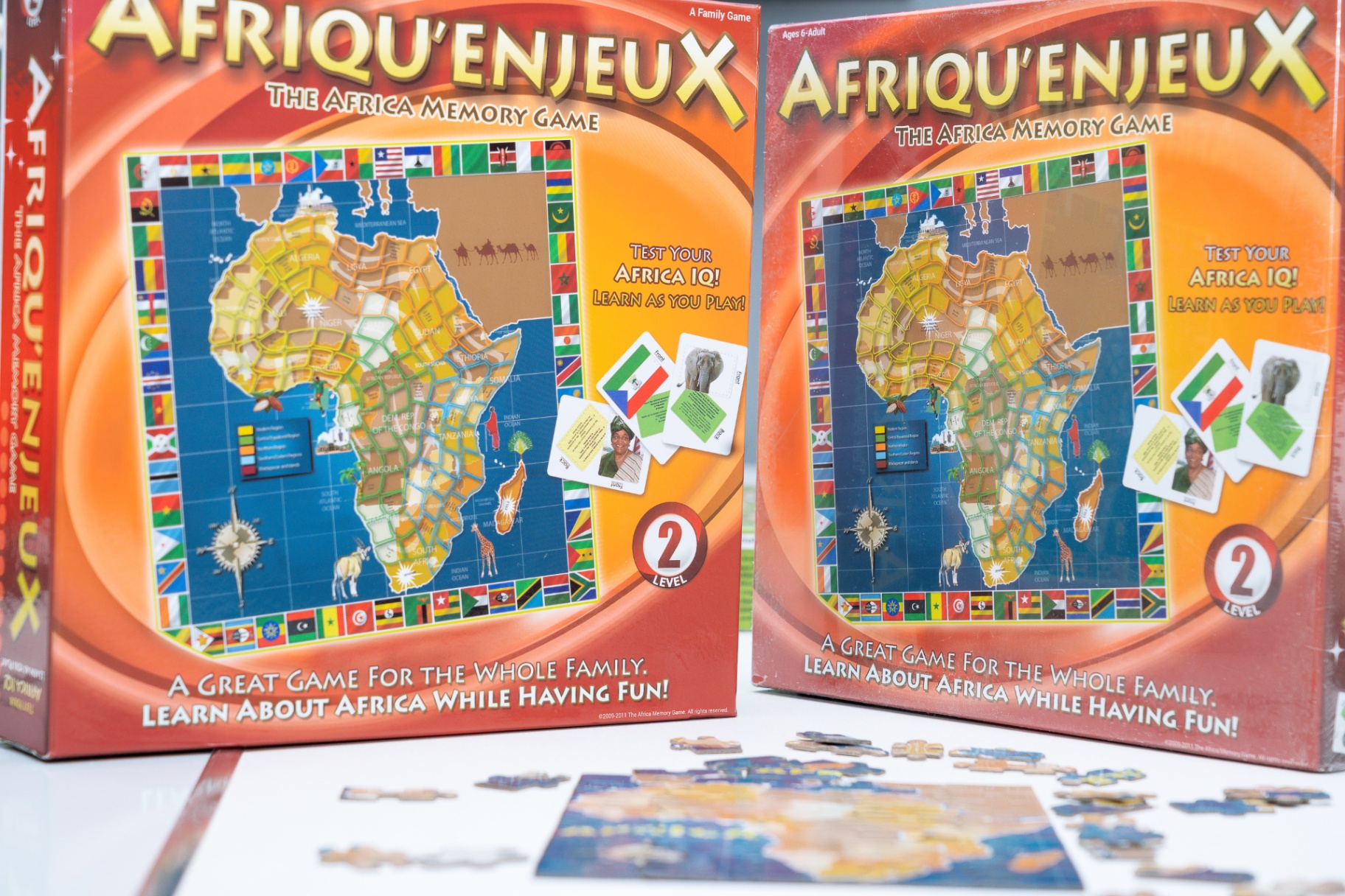 Two editions of the box beside a puzzle in progress